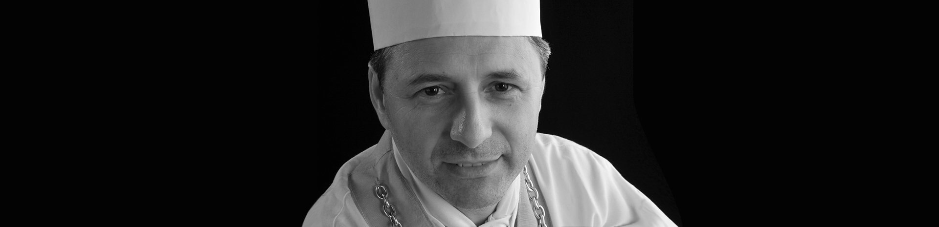 A chef in a white uniform and traditional hat, representing gourmet dining on board | MSC Cruises A chef in a white uniform and traditional hat, representing gourmet dining on board | MSC Cruises