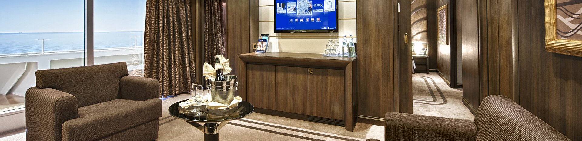 Luxurious cruise suite with sea view, elegant seating, and modern amenities | MSC Cruises Luxurious cruise suite with sea view, elegant seating, and modern amenities | MSC Cruises
